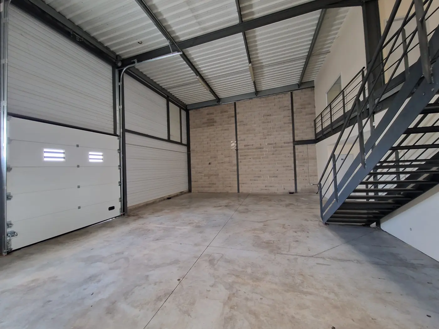 Entrepôt de stockage Camargue 4 vide de 250 m², porte sectionnelle et escalier mezzanine, Garosud Montpellier